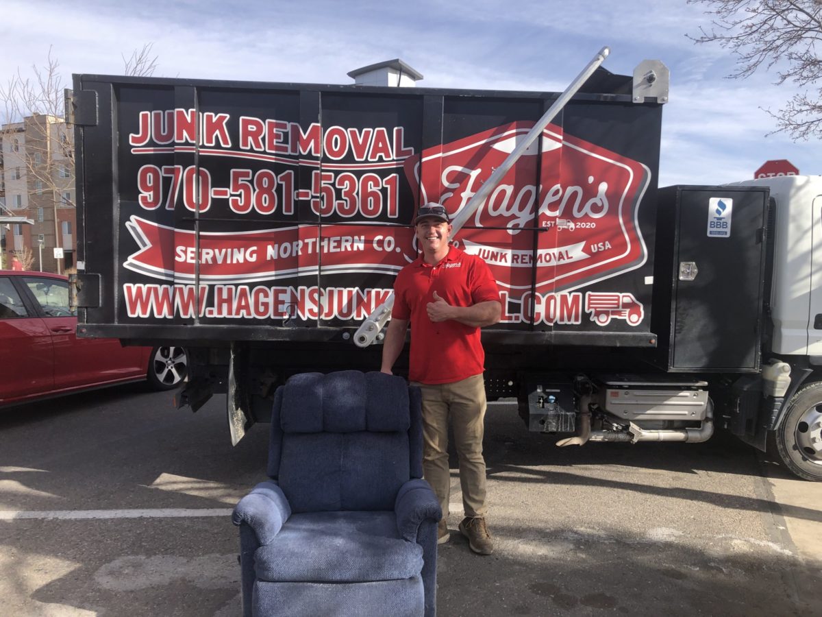 hagen's junk removal owner standing in front of truck with old chair