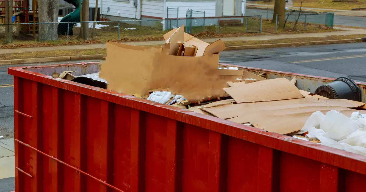 A red dumpster full of cardboard